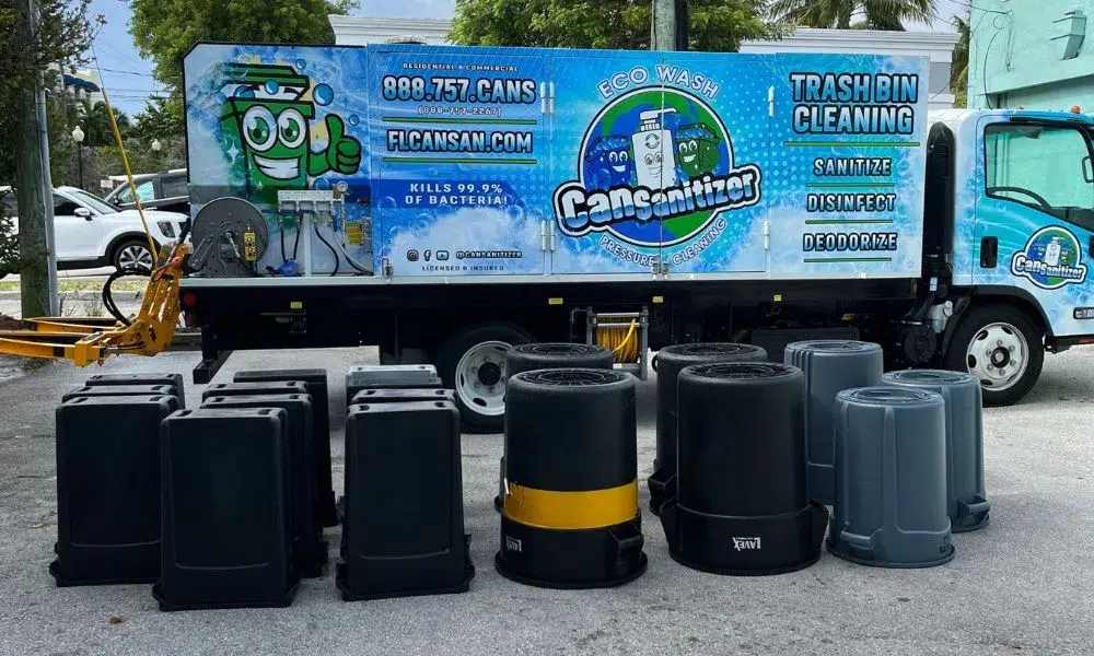 Fleet truck of a trash bin cleaning service with several overturned bins in front